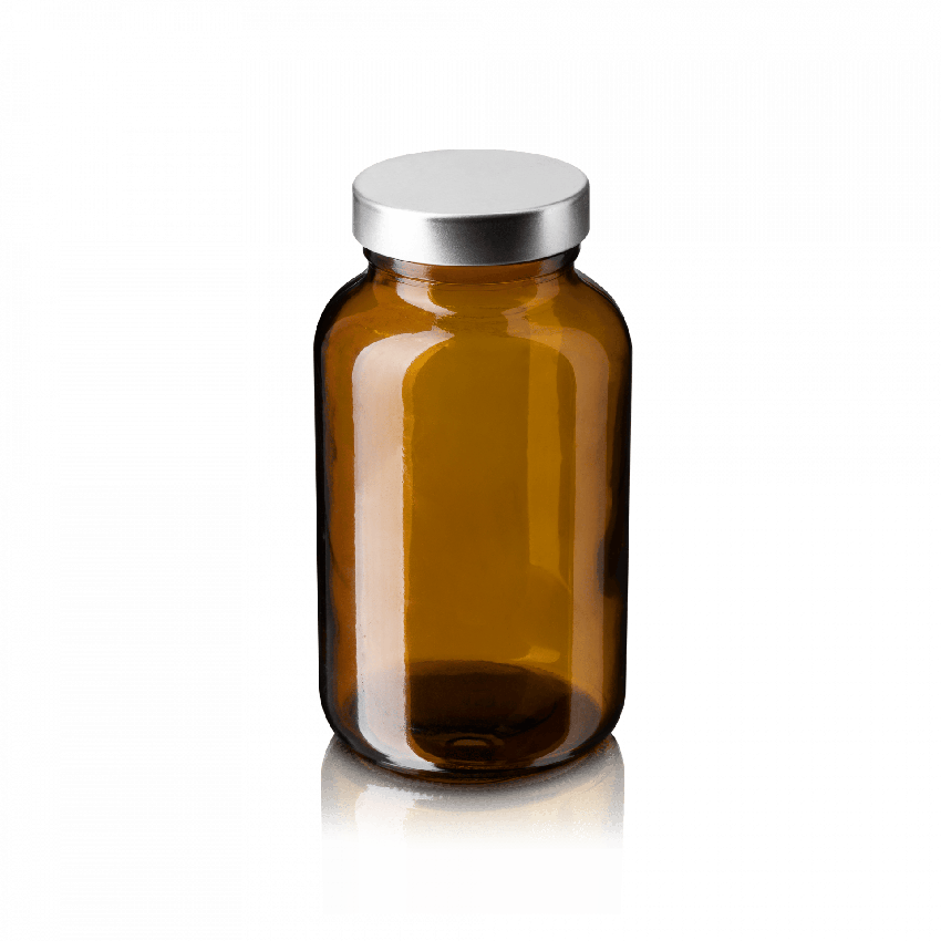 Empty amber glass supplement bottle with a silver cap isolated on a white background.