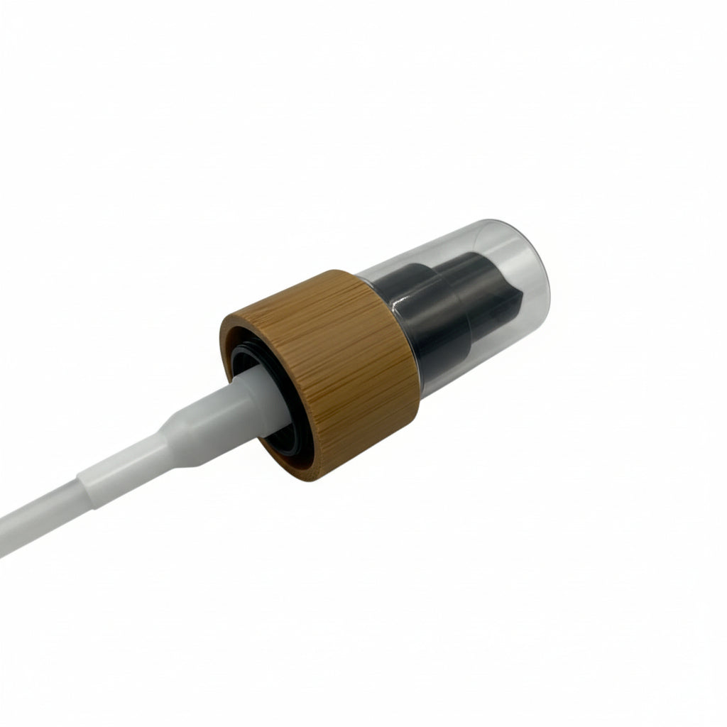 Cosmetic spray pump featuring a natural bamboo collar, black nozzle, and clear protective cap on a white background.